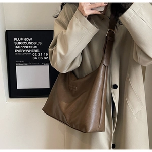 Gros plan d'un sac cabas rétro en cuir PU marron avec bandoulière réglable sur un mannequin