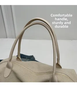 Dettaglio borsa in velluto a coste beige con manico in pelle PU e cerniera in metallo oro