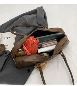 Detail shot showing the spacious interior of the brown faux leather tote bag with essentials