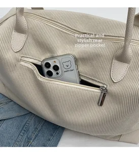 Dettaglio borsa da viaggio in velluto a coste beige con tasca posteriore a zip per cellulari