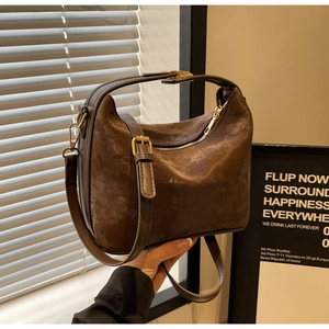 Vue détaillée du sac hobo vintage marron en daim doux avec accessoires en métal doré