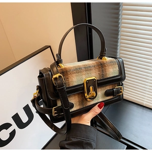 Close-up of retro plaid patchwork handbag featuring matte leather and gold turn-lock closure