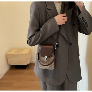 Close-up of minimalist retro mobile phone bag with brown leather flap and silver buckle