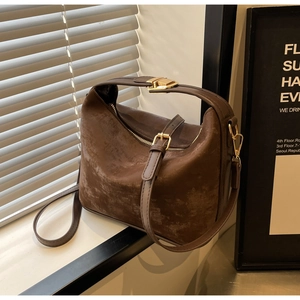 Détail d'un sac à bandoulière marron mat vintage avec des ferrures dorées et élégantes