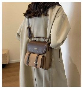Brown retro patchwork leather backpack worn by a model in a beige trench coat