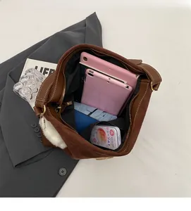 Top view of large brown tote bag showing spacious interior with tablet and notebooks