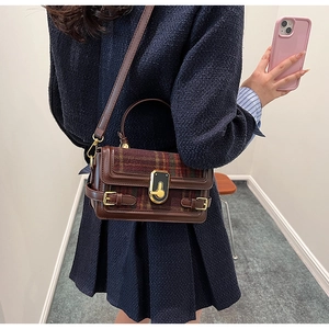 Classic British style plaid handbag with leather trim and gold buckle details shown on model