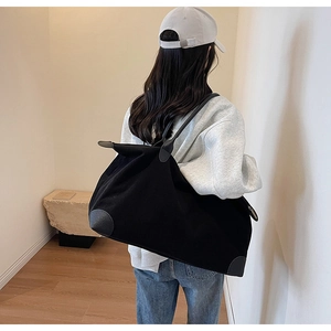 Dettaglio della borsa tote in velluto nero con tessuto testurizzato e angoli rinforzati in pelle