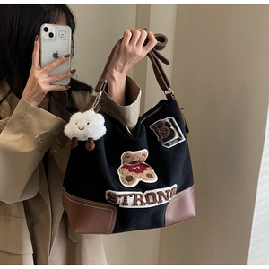 Detail of large tote bag with teddy bear patchwork and plush cloud charm accessory