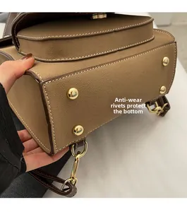 Detail view of four golden anti-wear rivets on brown faux leather backpack bottom