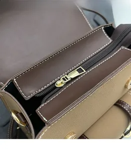 Macro shot of smooth gold-tone zipper hardware on a two-tone leather vintage backpack