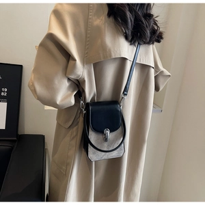 Detail view of retro crossbody phone bag with marble pattern on a khaki trench coat
