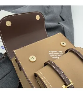 Close-up of the vintage brown magnetic buckle closure with contrast stitching detail
