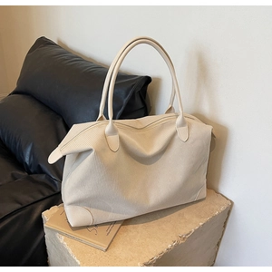 Dettaglio della borsa tote in velluto beige con trama a coste e manici in pelle