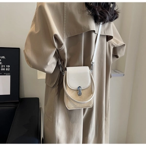 Detail of vintage beige crossbody phone bag with silver cylindrical rotary lock