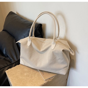 Dettaglio del tessuto in velluto a coste beige e finiture in pelle di questa borsa tote