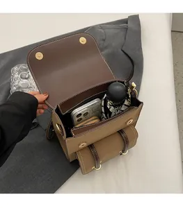 Macro view of interior storage showing phone, wallet and umbrella in brown leather bag