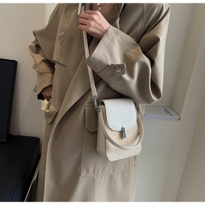 Detail of vintage style crossbody phone bag with two-tone leather and silver clasp buckle