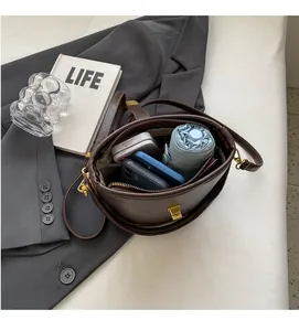 Detail showing the large capacity of the dark brown bucket bag for phone and umbrella