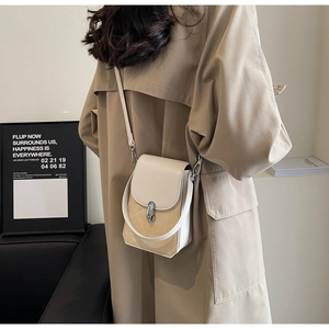Close-up of a two-tone beige crossbody phone bag with a silver lock and top handle
