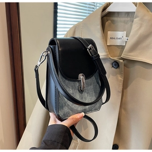 Detail of small rectangular crossbody bag with silver twist lock and denim leather texture