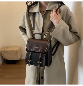 Detailed side view of a vintage leather backpack with contrast stitching on model
