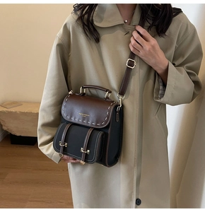 Close-up of vintage bicolour leather bag with contrast stitching and metal hardware details