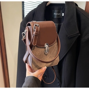 Detail showing vintage brown leather patchwork crossbody bag with silver magnetic snap