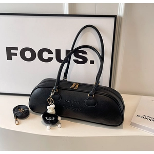Detail of black Boston bag featuring lychee texture leather and fuzzy monster charm