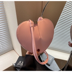 Dettaglio di una borsa rosa a forma di cuore con texture in pelle e cerniera