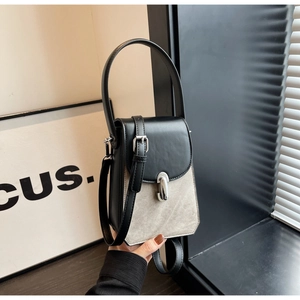 Detailed shot of vertical patchwork phone bag with silver metal clasp and top handle