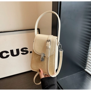 Detail of vintage beige crossbody phone bag showing metallic clasp and textured finish