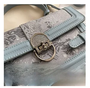 Détails du tissu jacquard, coutures en cuir bleu clair et boucle métallique