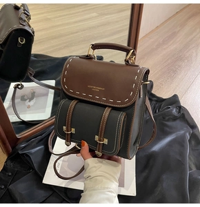 Detail of vintage patchwork leather backpack with white stitching and metal buckles