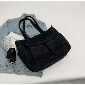 Detail of black corduroy tote bag with front pockets and adjustable strap for daily use