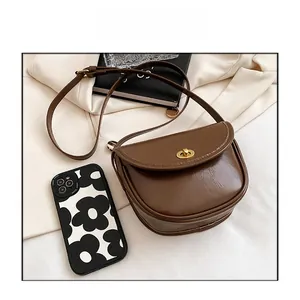 Brown saddle bag size comparison featuring a polished surface and golden twist lock