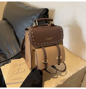Detail of the vintage contrast leather backpack with white stitching and metal buckle