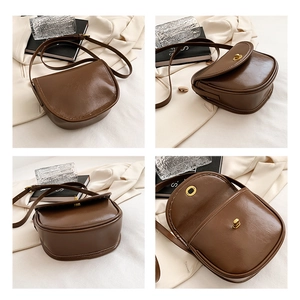 Detail view of brown leather saddle bag showing metal buckle and internal structure