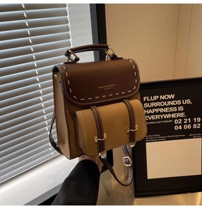 Detail of retro leather backpack with brown flap and contrast white stitching accents