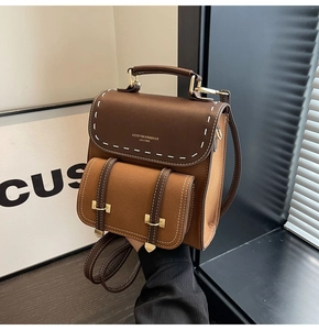 Close-up of contrast stitching on retro brown leather backpack with gold hardware details