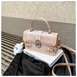 Détail du sac carré en jacquard avec boucle métallique ronde et breloque boule en peluche