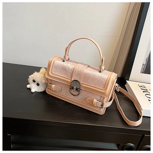 Gros plan d'un sac à main en jacquard rose avec boucle en métal et breloque en peluche