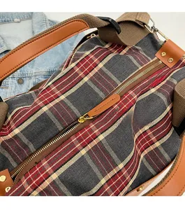 Detailed macro view of smooth golden metal zipper and red tartan plaid fabric texture