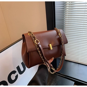 Détail du sac cabas en cuir marron avec fermoir doré et bandoulière en chaîne
