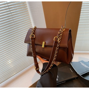 Détail du sac cabas marron foncé avec boucle dorée et bandoulière en chaîne