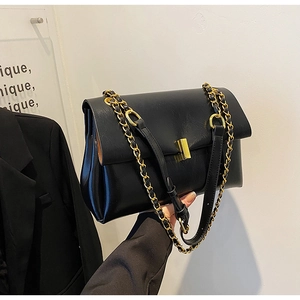 Détail du sac bandoulière noir en similicuir avec fermoir doré et bandoulière chaîne