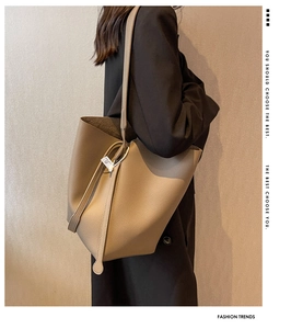 Detailed close-up of large earth-tone pebbled leather bucket bag with shoulder strap