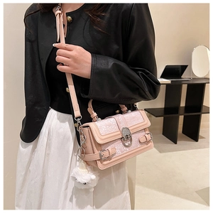 Détail d'un sac à main rose en cuir PU avec motif floral gaufré et breloque peluche