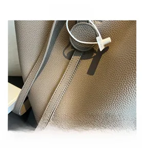 Detail of grey lychee pattern leather bucket bag showing refined texture and stitching