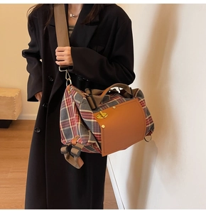 Detail of vintage plaid canvas backpack with leather trim and metal twist lock closure